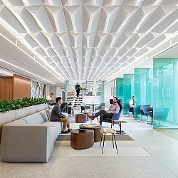 A group of people sitting in a room with a large white ceiling.