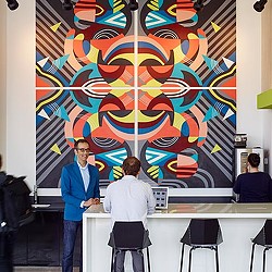 A few people standing in front of a large map.
