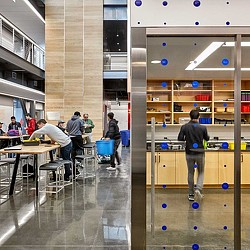 People in a room with tables and chairs.