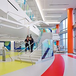 A couple of people walking down a flight of stairs.