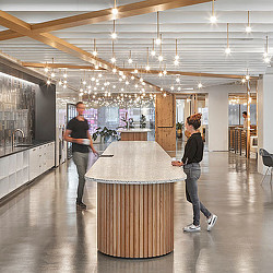 A couple of people standing next to a large table in a room.