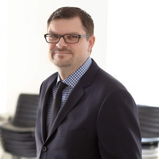 A man wearing glasses and a suit.
