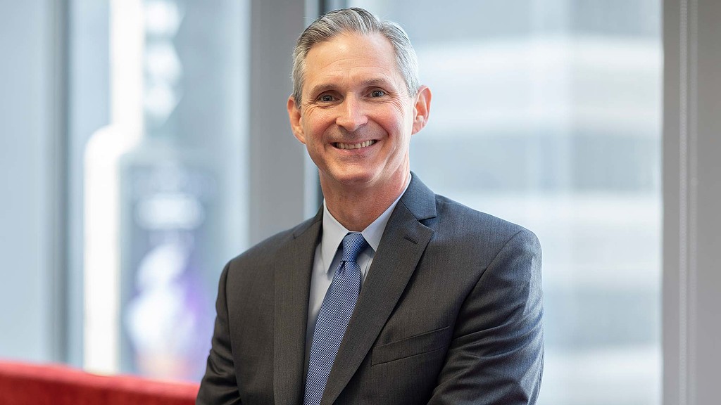 A man in a suit smiling.