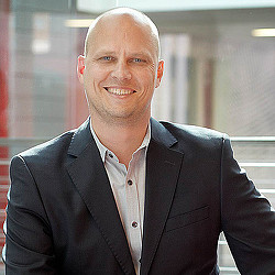 A man in a suit smiling.