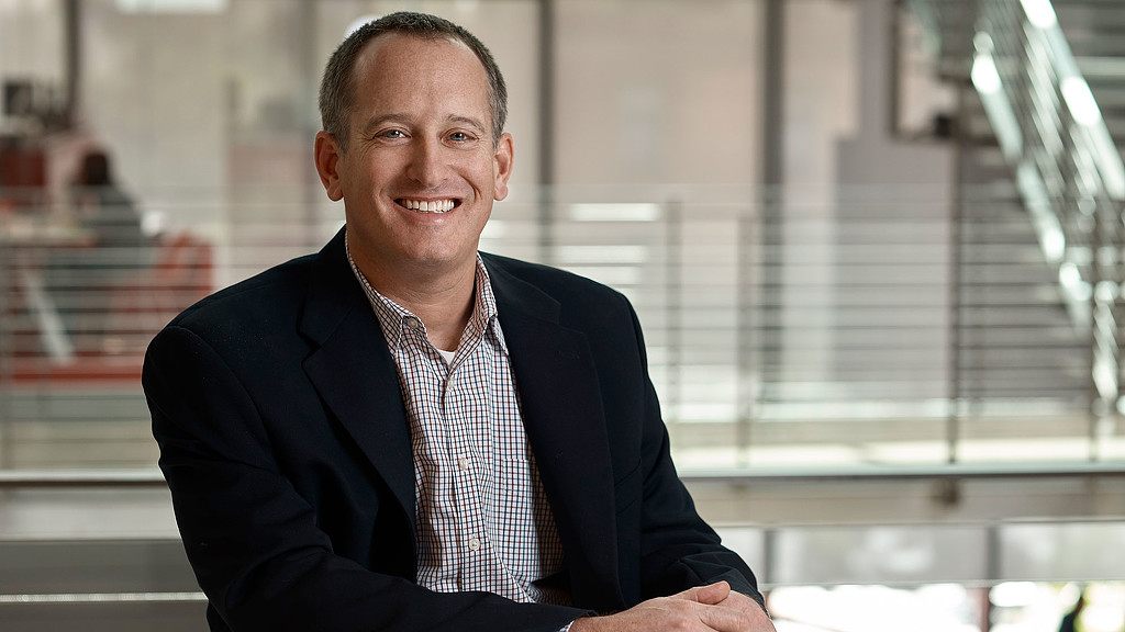 A man in a suit smiling.