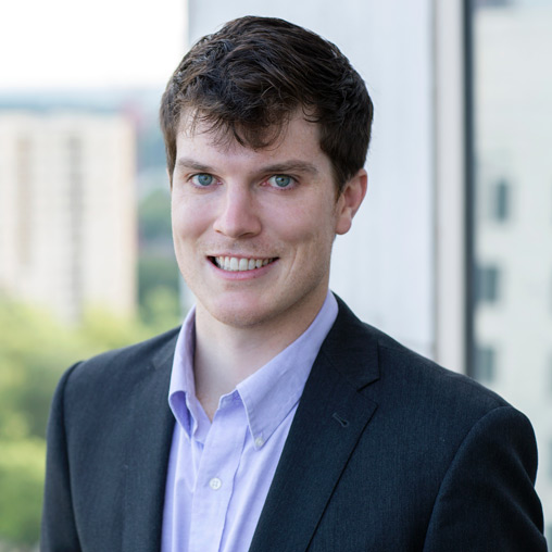 A man in a suit smiling.