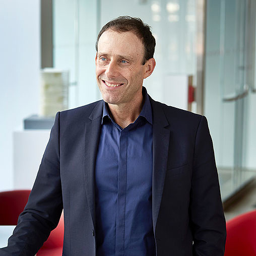 A man in a suit smiling.
