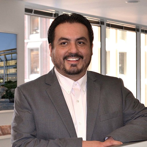 A man in a suit smiling.