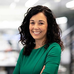 A woman with dark hair smiling.