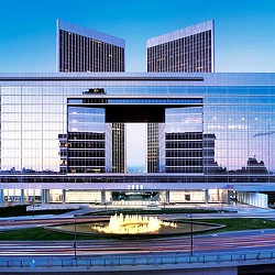 A large building with a pool in front of it.