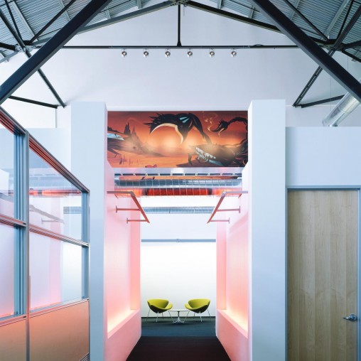 A room with a red wall and a painting on the wall.