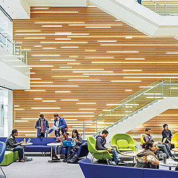 A group of people sitting in a room with a staircase.