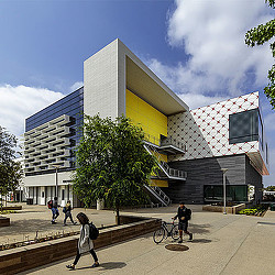 A group of people walking around a building.