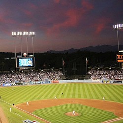 A baseball field with a crowd watching.