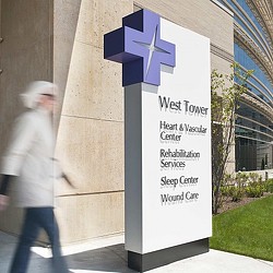 A person walking by a sign.