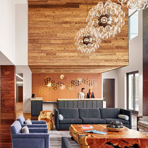 A room with a couch and a table with a chandelier.