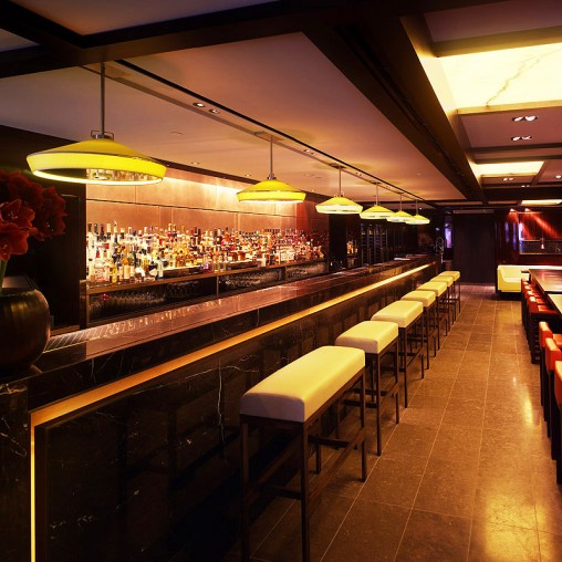 A bar with stools and a bar with lights.