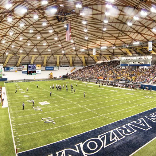 A football stadium with a crowd watching.