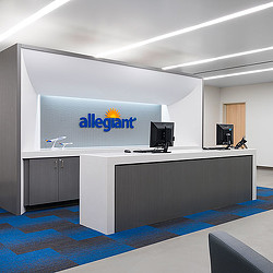 A room with a large screen and a desk with a computer.