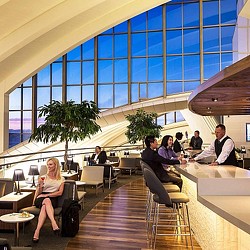 A group of people sitting in a room with a large glass wall.
