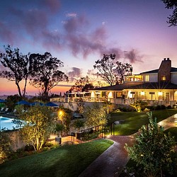 A house with a pool and trees in the front.