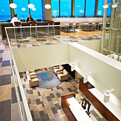 A large room with a glass floor and a couple of people sitting at a table with a large.