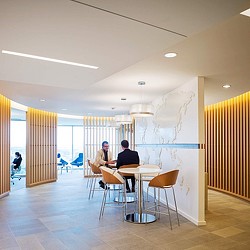 A couple of people sitting at a table in a room with a large window.