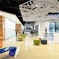 A room with a few people and a few tables and chairs.