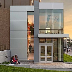 A couple of women sitting on steps outside of a building.