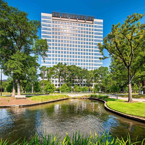 A building with a pond in front of it.