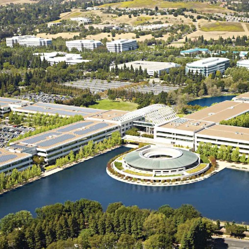 A large building with a pool in front of it.