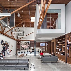 A room with a few people and a large bookcase.