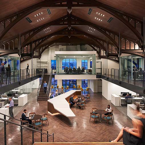 A group of people sitting at tables in a large building.