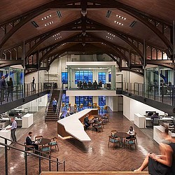 A group of people sitting at tables in a large building.