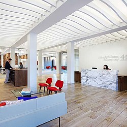 A room with a bed and chairs.