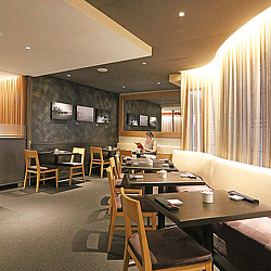 A person standing in a room with tables and chairs.