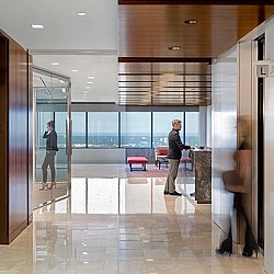 A man and woman standing in a room with glass doors.