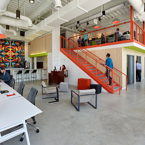 A room with a staircase and tables.