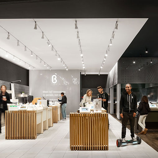 A group of people standing in a room with a table and chairs.