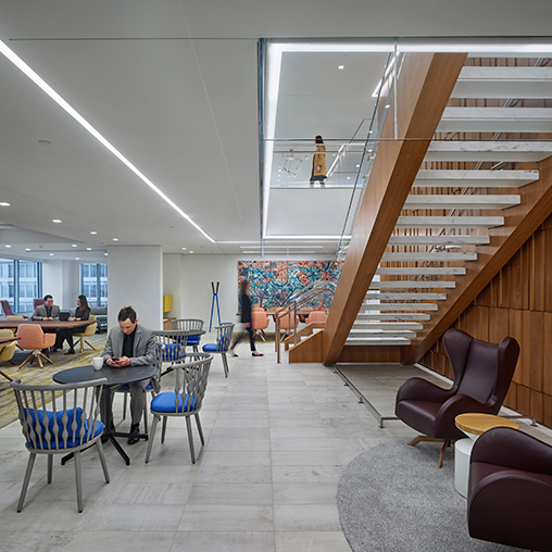 A room with people sitting at tables and chairs.