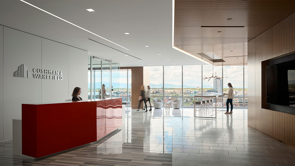 A room with a large glass wall and a large red table with people walking around.