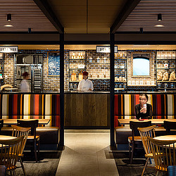 A couple of people sitting at a table in a restaurant.