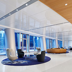 A room with a large window and a couch and chairs.