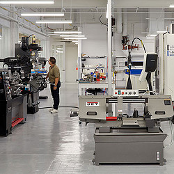 A person standing in a room with machines.