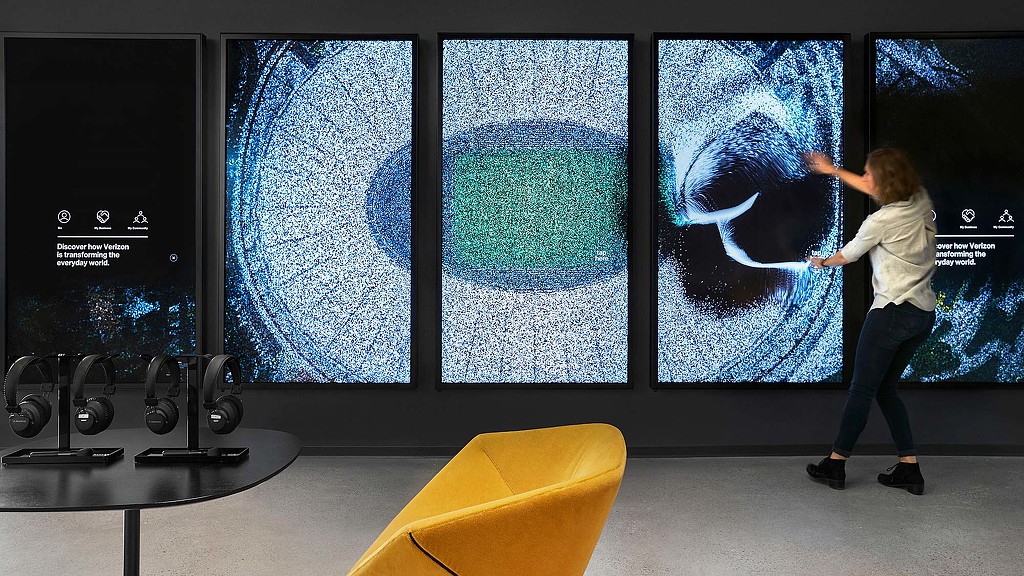A person standing in front of a large screen.