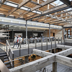 A couple of people walking in a large building.