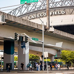 A group of people walking under a bridge.
