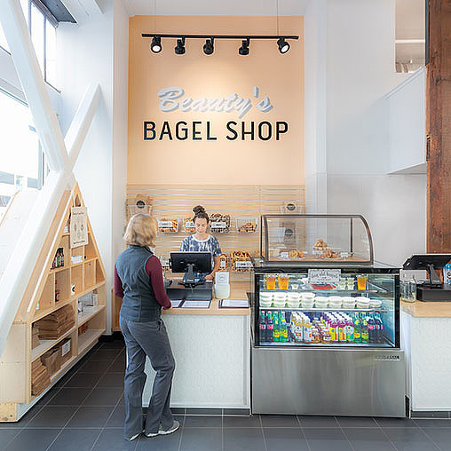 A person standing in front of a counter with a sign on it.