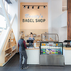 A person standing in front of a counter with a sign on it.