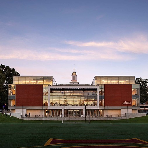A large building with a field in front of it.